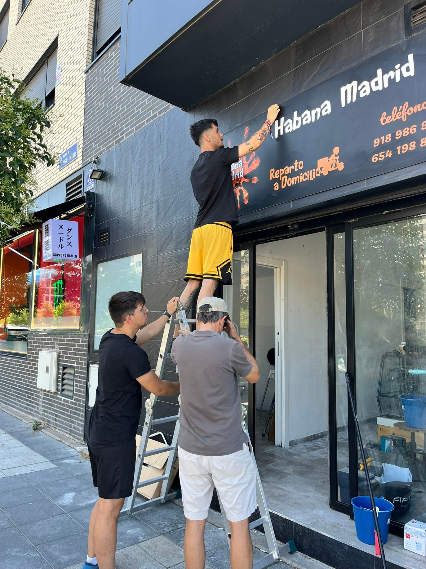 Montando el cartel de Forno Gamberro en la fachada del local